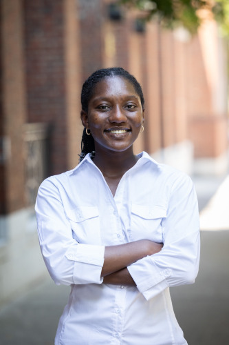 headshot of Emmanuela smiling in white shirt