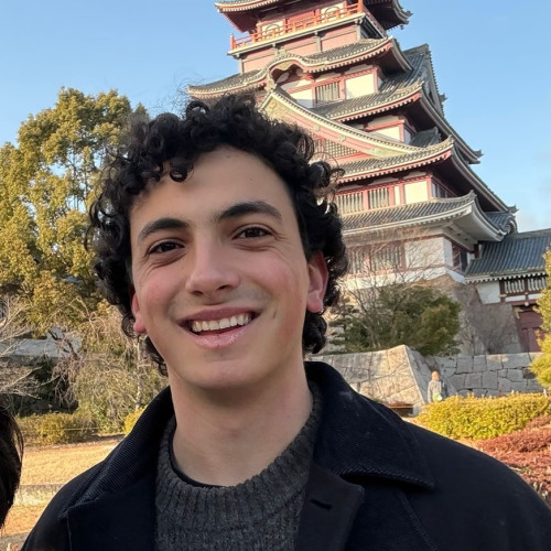 camilo smiling to camera with a traditional japanese pagoda behind